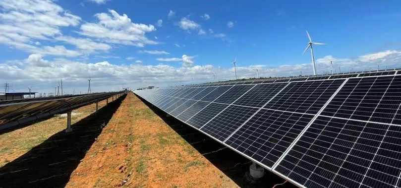 Solar panels and wind turbines in field