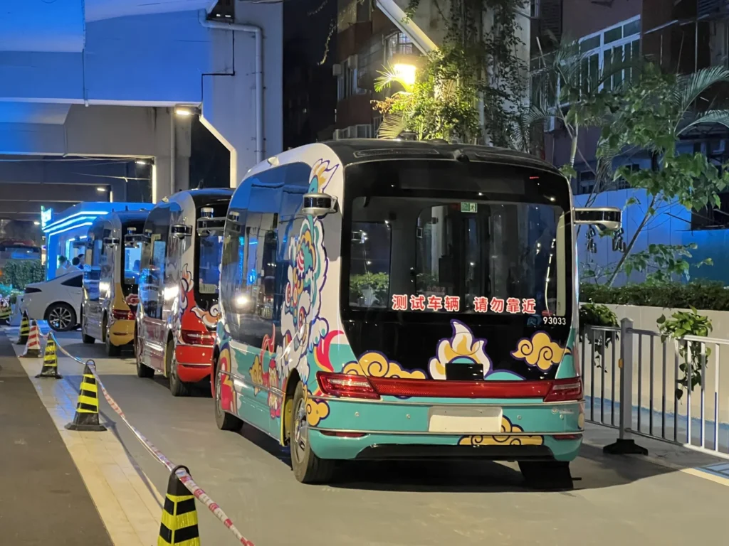 Colorful autonomous shuttles parked at night