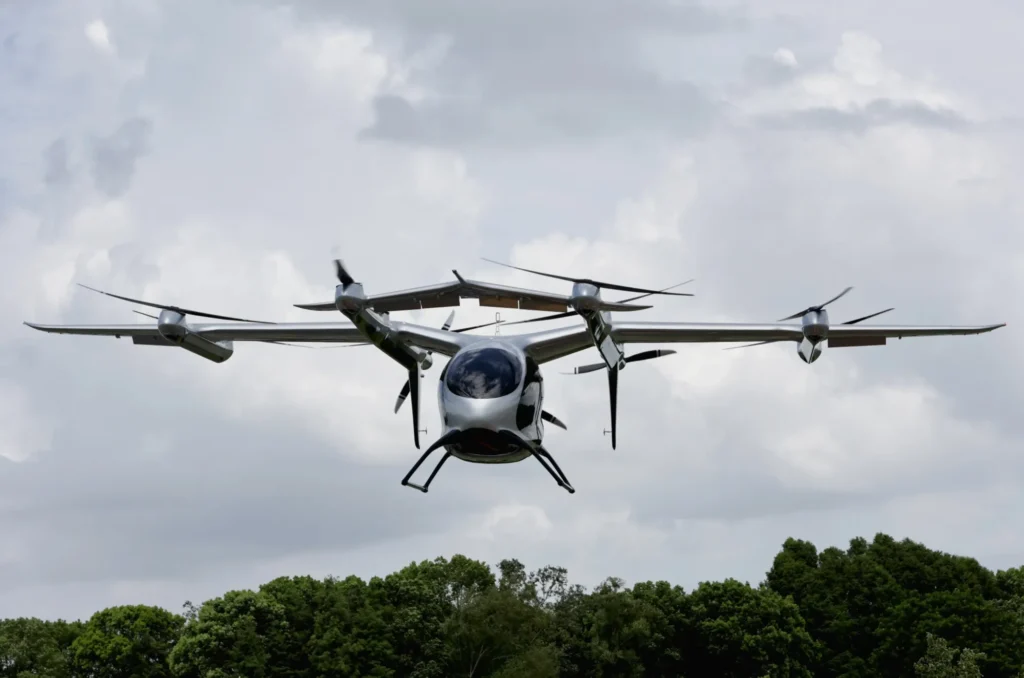 Electric VTOL aircraft flying above trees under a cloudy sky