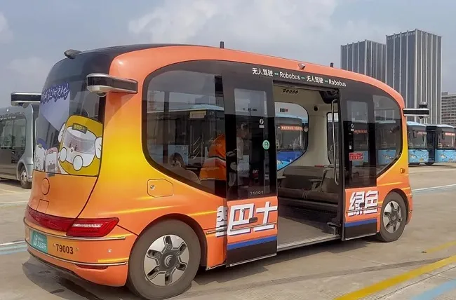 Orange autonomous shuttle at a transport station