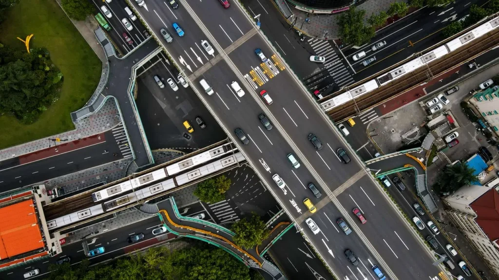 Aerial view of a busy urban road network with multiple transport routes and vehicles.