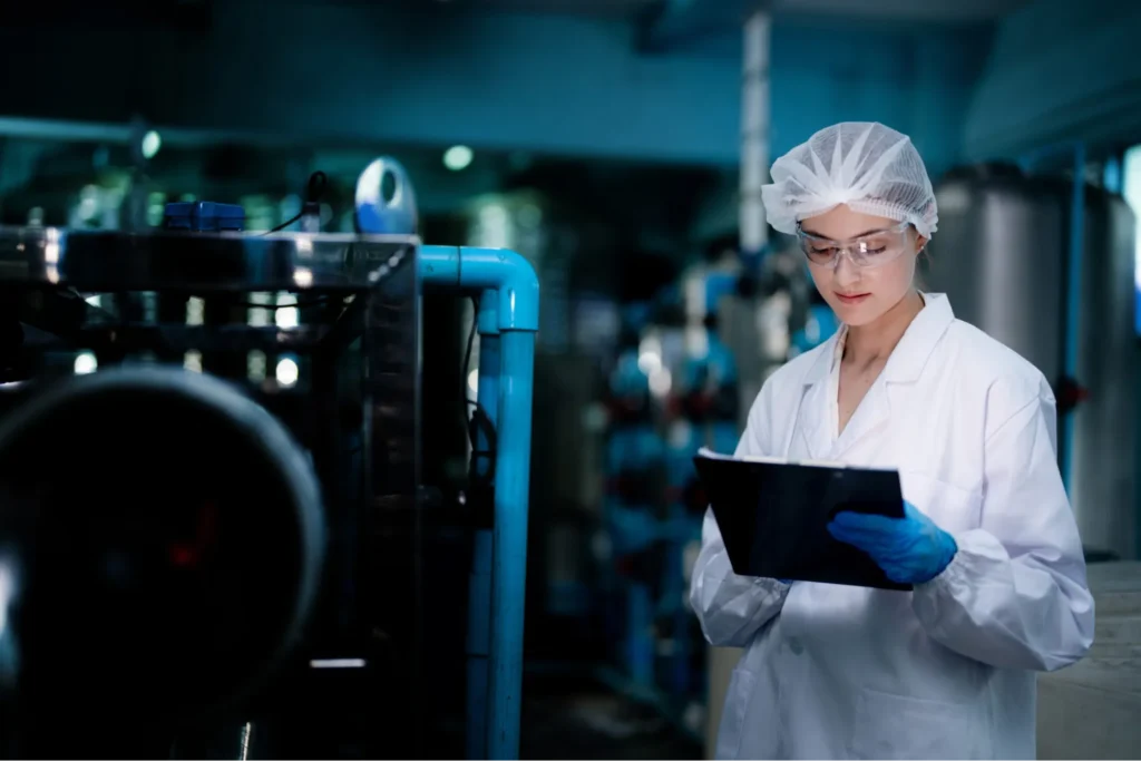 Biotech researcher inspecting equipment in a manufacturing facility